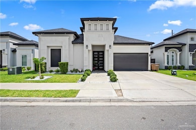 View of front of property featuring a garage, concrete driveway, french doors, a front yard, and a shingled roof