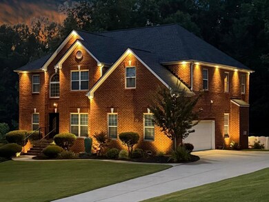 View of front of property with driveway, a garage, brick siding, and a front yard