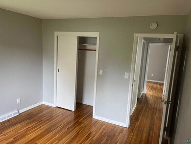 Unfurnished bedroom with a closet and hardwood / w