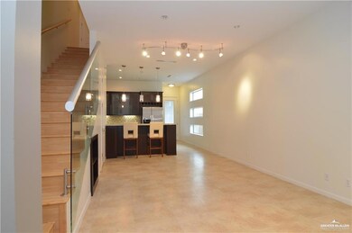 Kitchen featuring stainless steel fridge with ice dispenser, rail lighting, light tile floors, backsplash, and a kitchen island