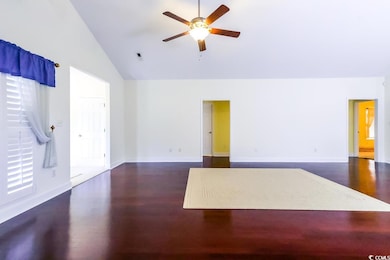Unfurnished living room featuring ceiling fan, wood finished floors, high vaulted ceiling, and baseboards