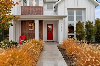 View of exterior entry featuring board and batten siding, a porch, and brick siding
