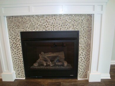 Ceramic tile surround on gas log fireplace.