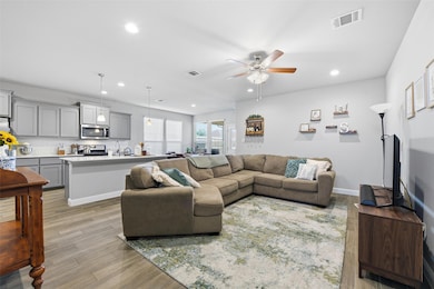 Living area with recessed lighting, light wood-style flooring, and ceiling fan