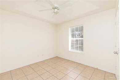 Unfurnished room with tile patterned flooring, ceiling fan, and a raised ceiling