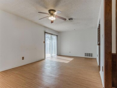 Empty room with ceiling fan, a textured ceiling, a