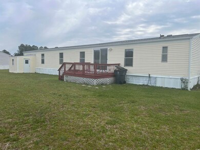 Rear view of property with a deck and a lawn