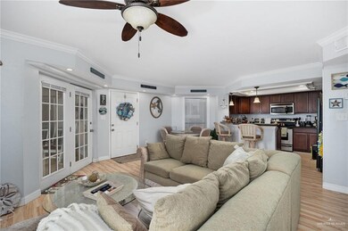 Living room with crown molding, french doors, ceiling fan, and light wood-type flooring