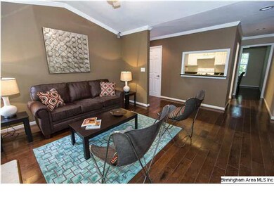 Living room with hardwood floors, painted brick fi