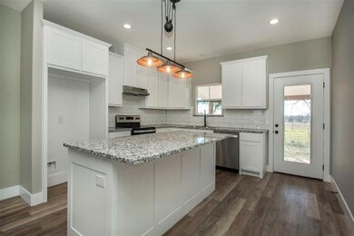 Kitchen with white cabinets, a center island, and appliances with stainless steel finishes