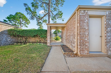 The walkway leads to the back entry of the garage, surrounded by mature landscaping and a private gated courtyard for added charm and functionality.
