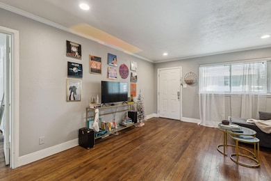 Living area featuring baseboards, crown molding, w