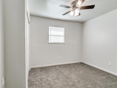 Unfurnished room with ceiling fan and dark carpet