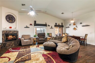 Living room featuring ceiling fan, a fireplace, da