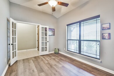 Double French doors create a stylish entrance and a seamless transition between work and relaxation in this home office/flex space.