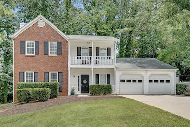 Property entrance featuring a balcony, driveway, and covered porch
