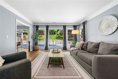 Living room featuring crown molding, lip flooring,