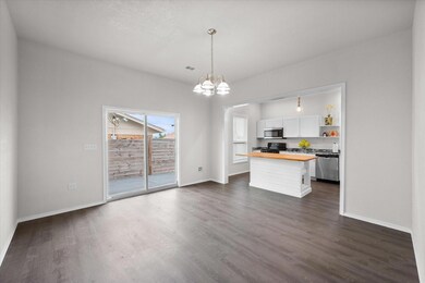 Kitchen featuring hanging light fixtures, wood counters, white cabinetry, dark hardwood / wood-style floors, and appliances with stainless steel finishes