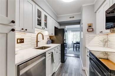 Kitchen featuring white cabinetry, backsplash, bla