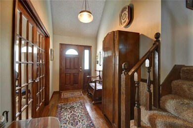 The entryway features wood floors, vaulted ceiling