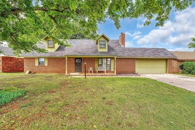 Cape cod home with a front lawn, a garage, driveway, and brick siding