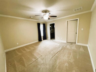 Unfurnished bedroom with ceiling fan, crown molding, and carpet floors