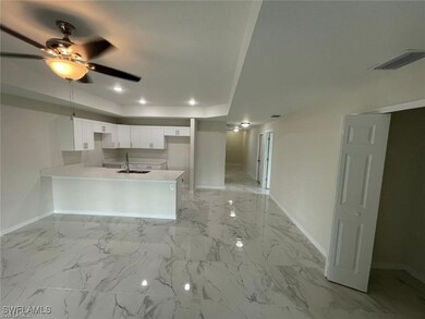 Kitchen featuring baseboards, a peninsula, a sink,