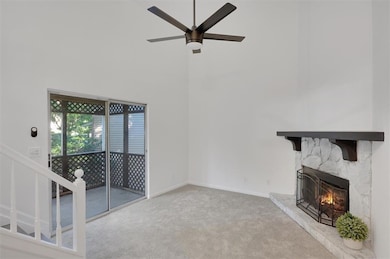 Unfurnished living room featuring carpet, a stone 