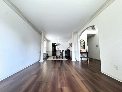 Living area with crown molding, arched walkways, a