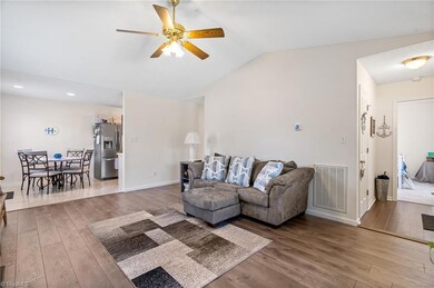 Living room with new laminate floors in 2021 and vaulted ceiling.