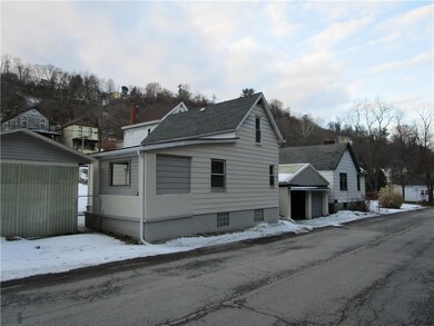 Back side view showing detached garage beside the