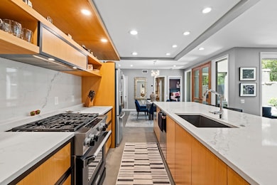 Kitchen featuring open shelves, a sink, recessed 