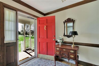 Covered front porch leads to foyer with chair rail