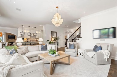 Living room with an inviting chandelier, arched wa