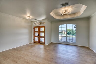Foyer entrance with visible vents, crown molding,