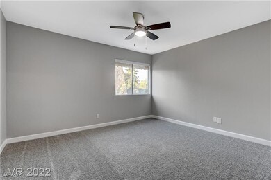 Carpeted spare room with baseboards and ceiling fa