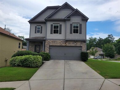 Craftsman house with stone siding, an attached garage, a front lawn, and concrete driveway