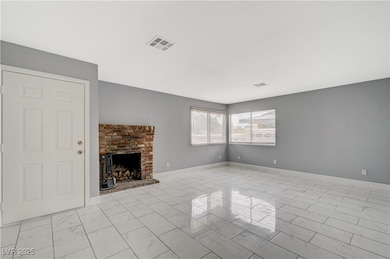 Unfurnished living room featuring light marble finish flooring and a fireplace