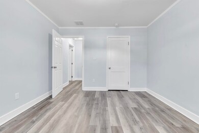 Unfurnished bedroom with baseboards, light wood fi