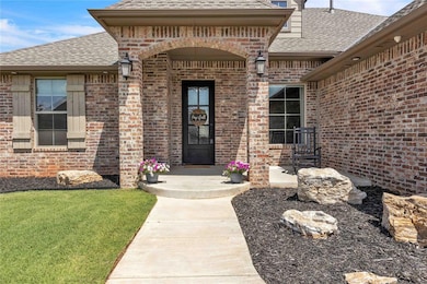 Doorway to property with roof with shingles, a lawn, and brick siding