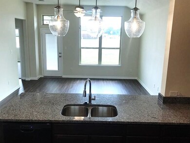 Kitchen featuring stone counters, black dishwasher