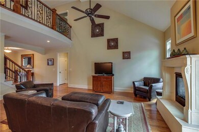 A view from the kitchen to the great room shows the vaulted ceiling and 2nd floor hallway.