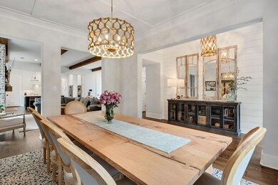 Dining area with a chandelier, wood finished floors, and beam ceiling
