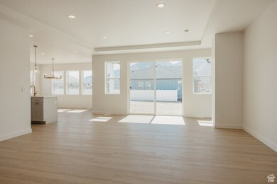 Spare room with light wood-style floors, a raised ceiling, recessed lighting, and a sunroom