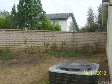 Side yard has roses and block walls all around