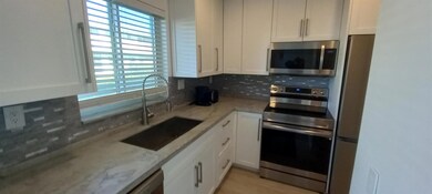One year old kitchen with wood cabinetry, stone co