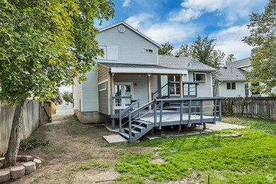 Rear view of property with a fenced backyard, a wooden deck, and a shingled roof