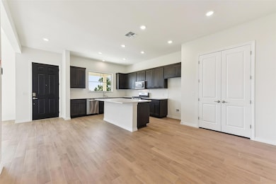 Kitchen with light countertops, a center island, 