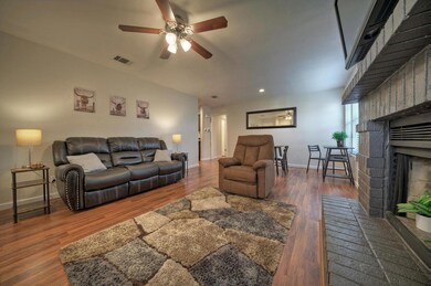 Living room with a fireplace, a ceiling fan, base