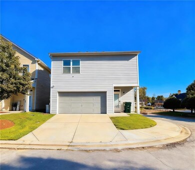 View of front of property featuring concrete driveway, a front yard, and a garage